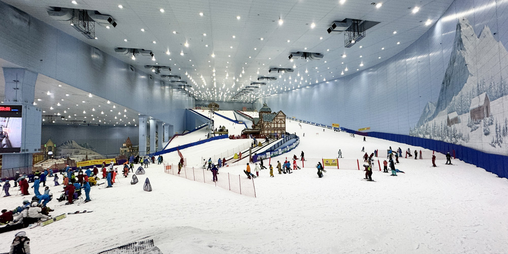 廣州融創雪世界室內滑雪場全景,展現寬闊的雪道和歐式小木屋裝飾