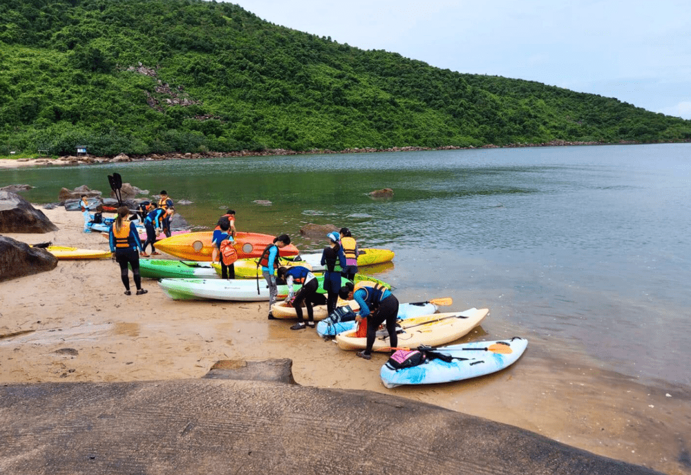 參加者穿著救生衣在海下灣海邊整理獨木舟與划槳